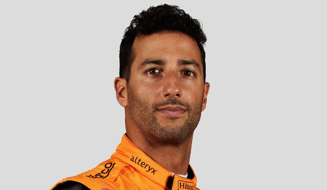 McLaren Racing driver Daniel Ricciardo in an orange and black jacket.
