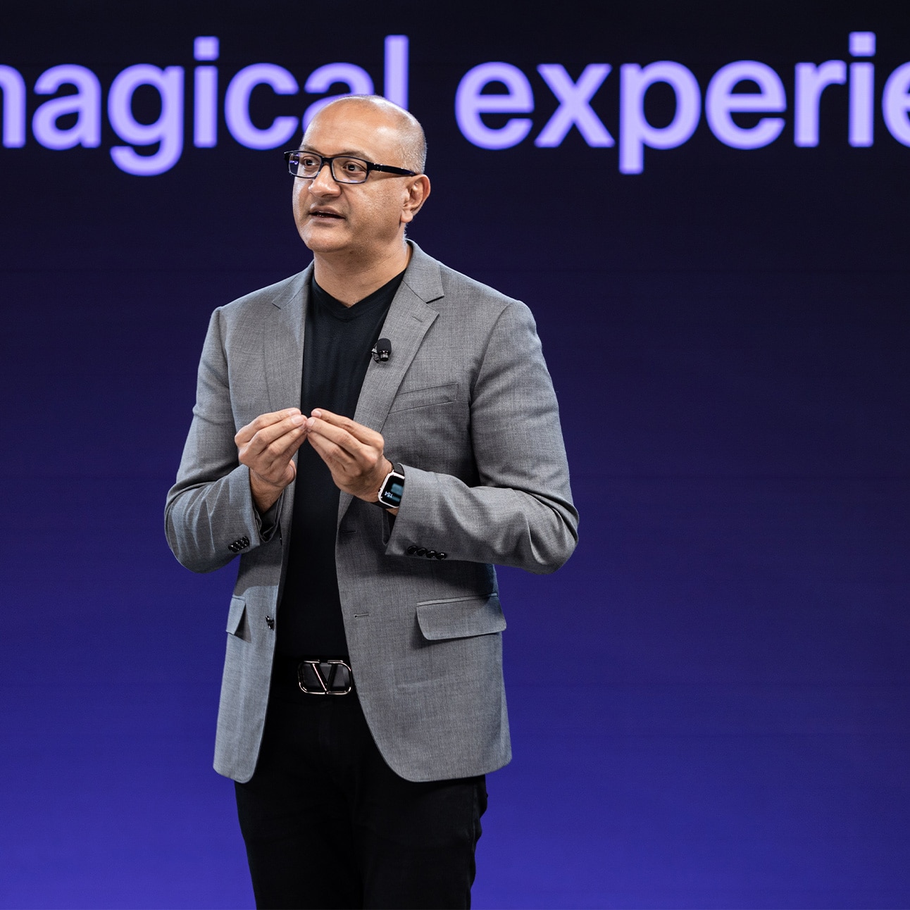 Individual in gray blazer speaks onstage at WebexOne.