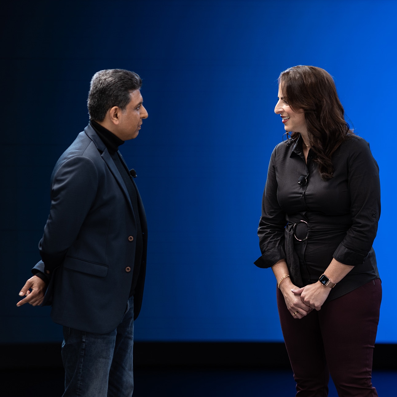 Two individuals interact onstage at WebexOne