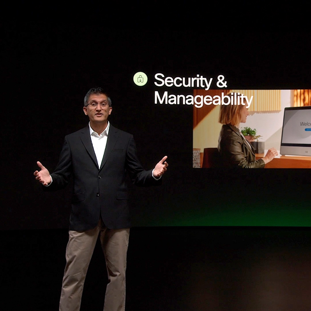 Cisco's Javed Khan presents onstage at WebexOne 2022. Screen behind him displays the words Security & Manageability.