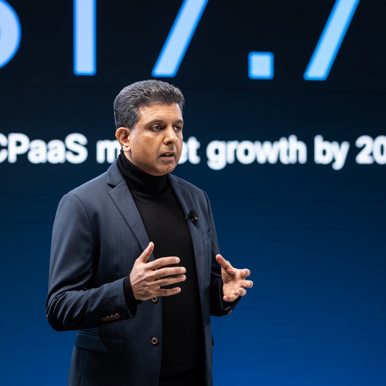  An individual in a navy blazer speaks onstage at WebexOne.